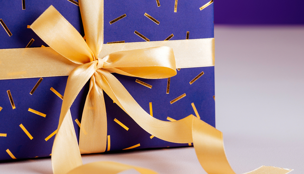 Pöydällä on kauniisti paketoitu lahjapaketti.