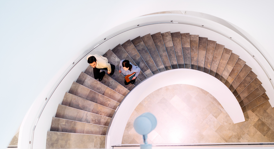 Kaksi henkilöä kävelee rappusia ylöspäin.