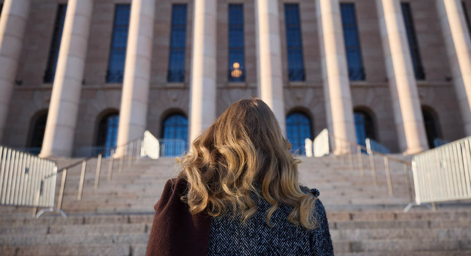 Henkilö kävelee kohti rakennusta.